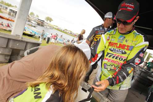 <p>
	Brent Chapman shows his fish to his children behind the stage.</p>
