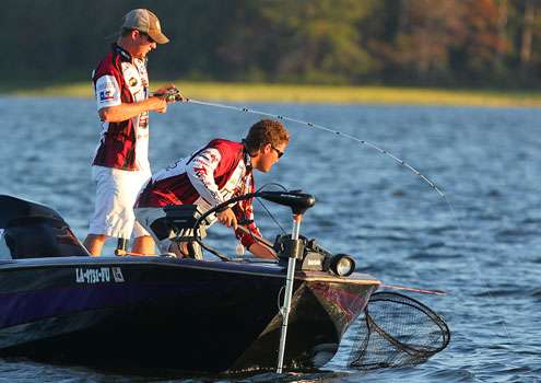 Clark hooks up with a fish while Pruett waits with the net.