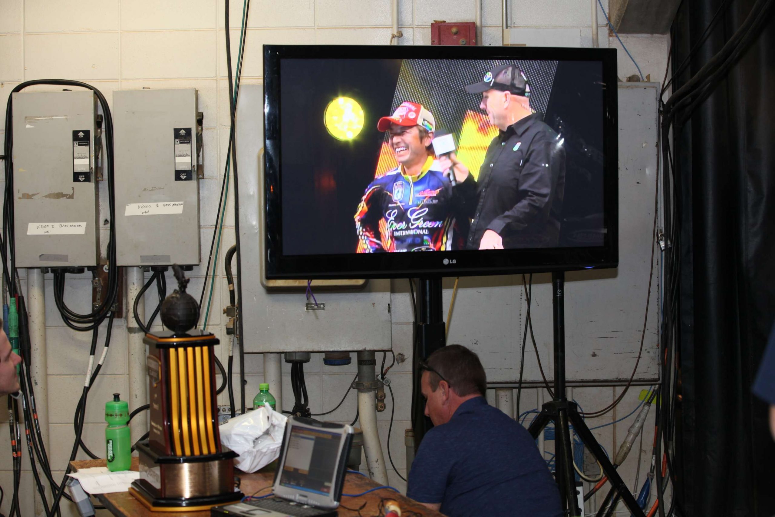The live feed plays on a TV backstage with a coveted item waiting nearby.