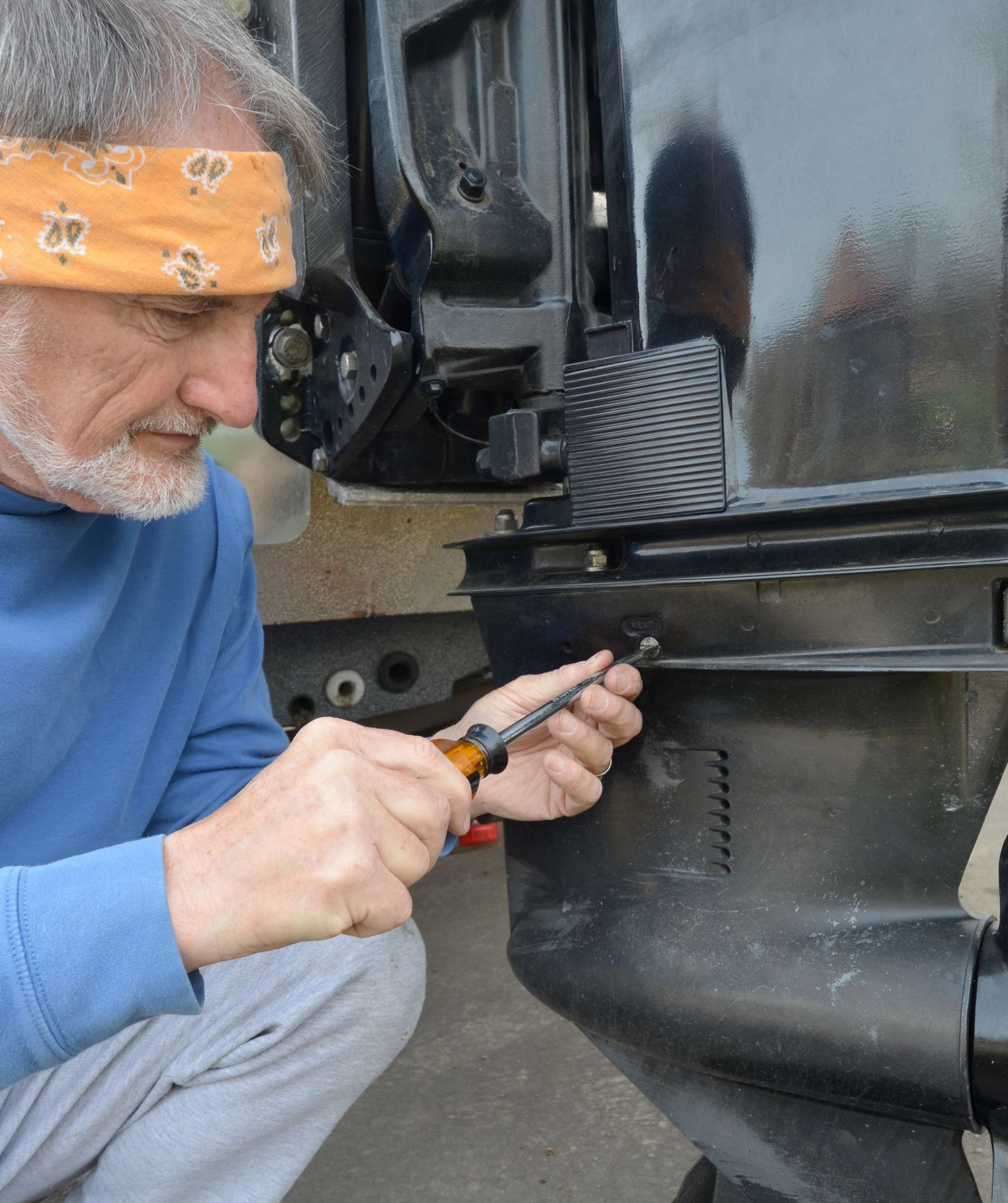 <em>CHANGING GEAR OIL</em>
<br>Tilt the outboard down. Place an oil pan under the lower unit and remove two screws. One screw is on top of the lower unitâ¦