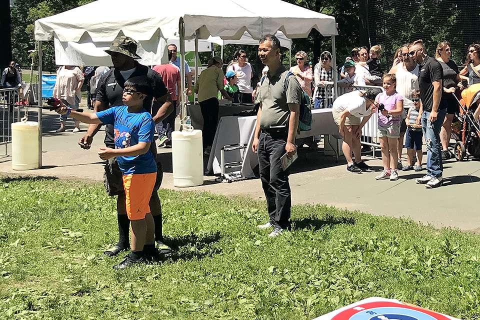 Volunteer Devon Norwood-Kitson, Montclair, N.J., gives guidance while this young fellowâs father watches. Kids of all ages, cultural backgrounds and skill levels received guidance and instruction.  