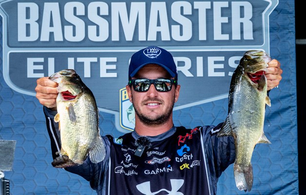 Chris Johnston holds two giant bass on the Bassmaster weigh-in stage.